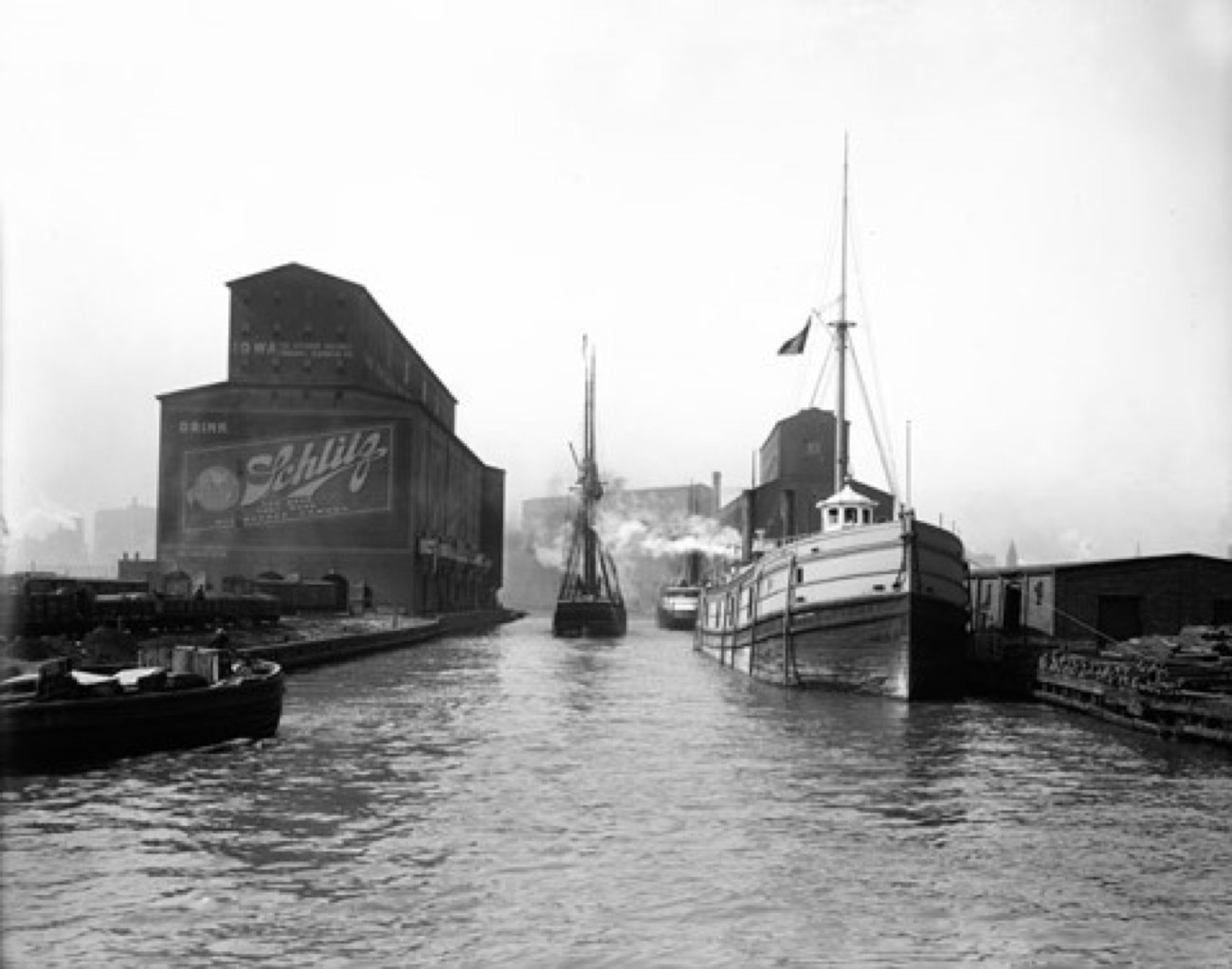 Archival photograph of ships on the Chicago River beside the Schlitz warehouse