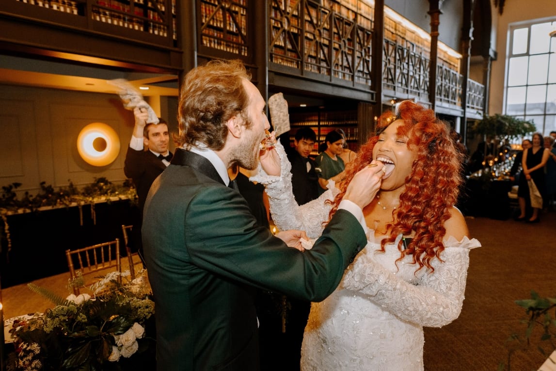 A couple sharing cake at their reception