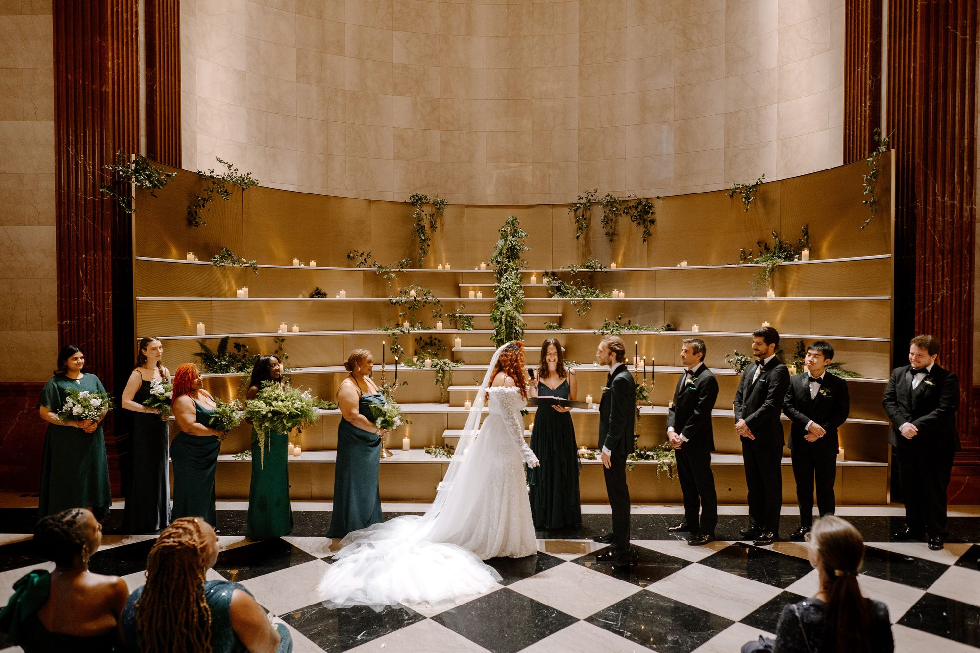 A wedding party gathered at the gold backdrop