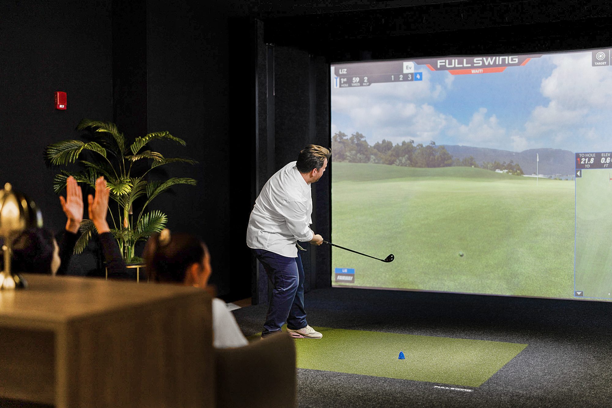Guests watching a shot at the golf simulator
