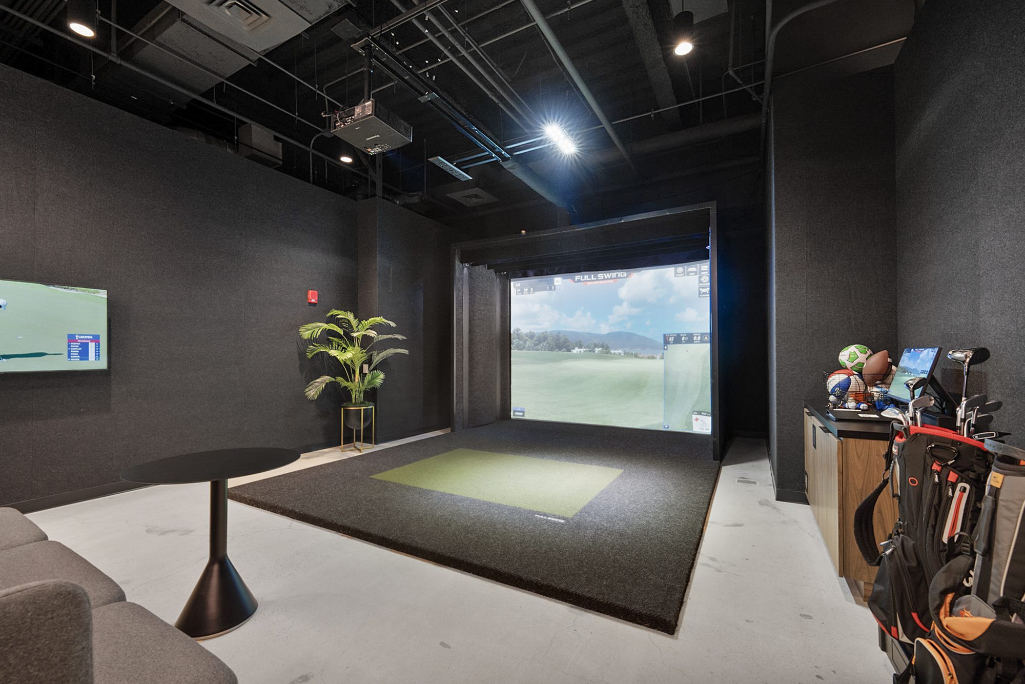 The golf simulator bay with clubs ready