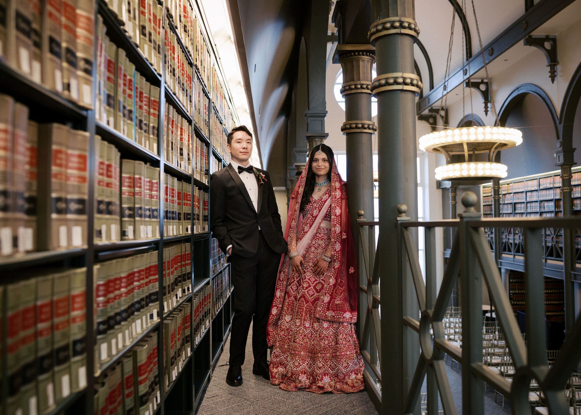 A couple in traditional attire among the bookshelves of The Library