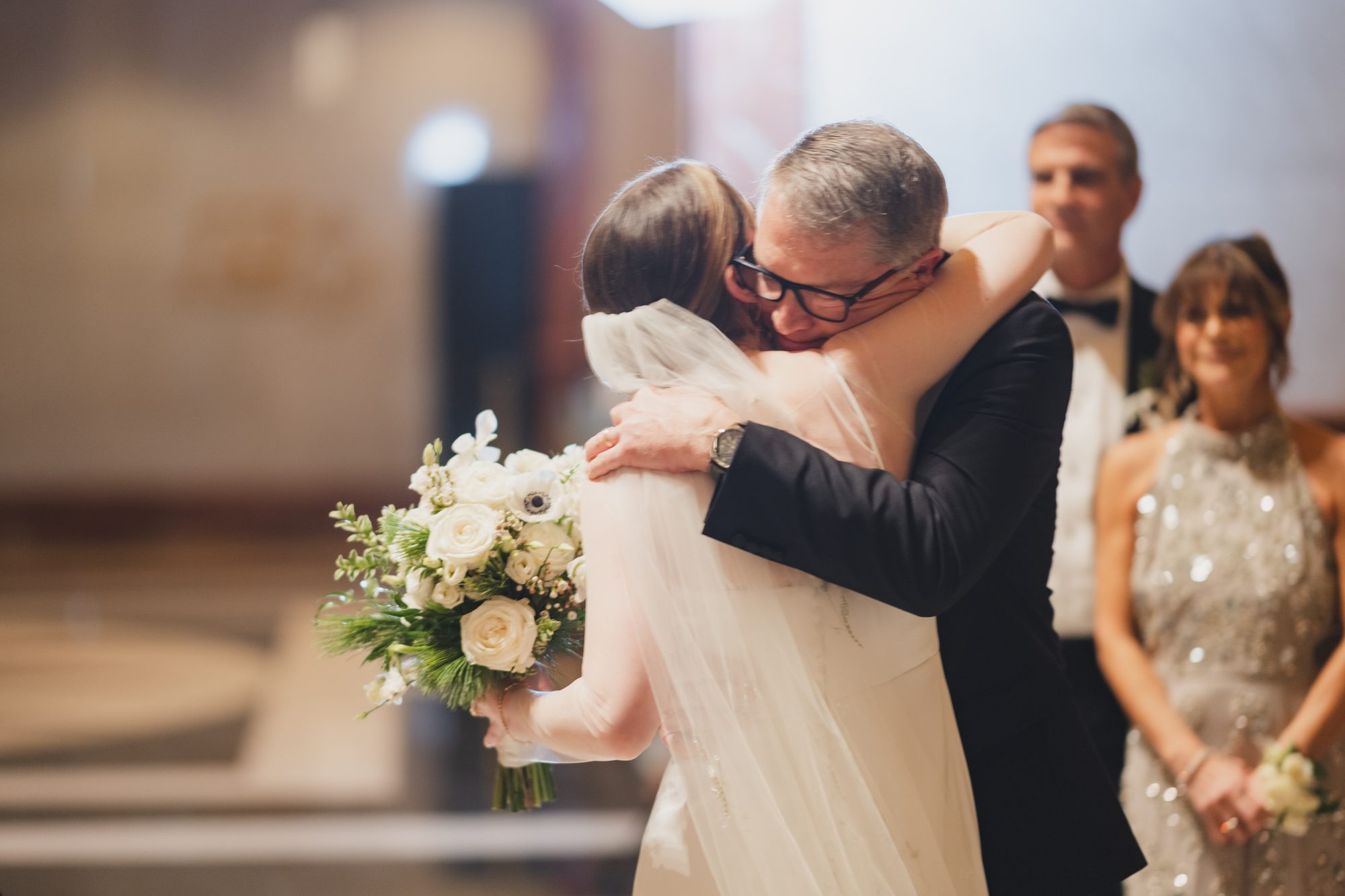 A bride embracing her father at the ceremony