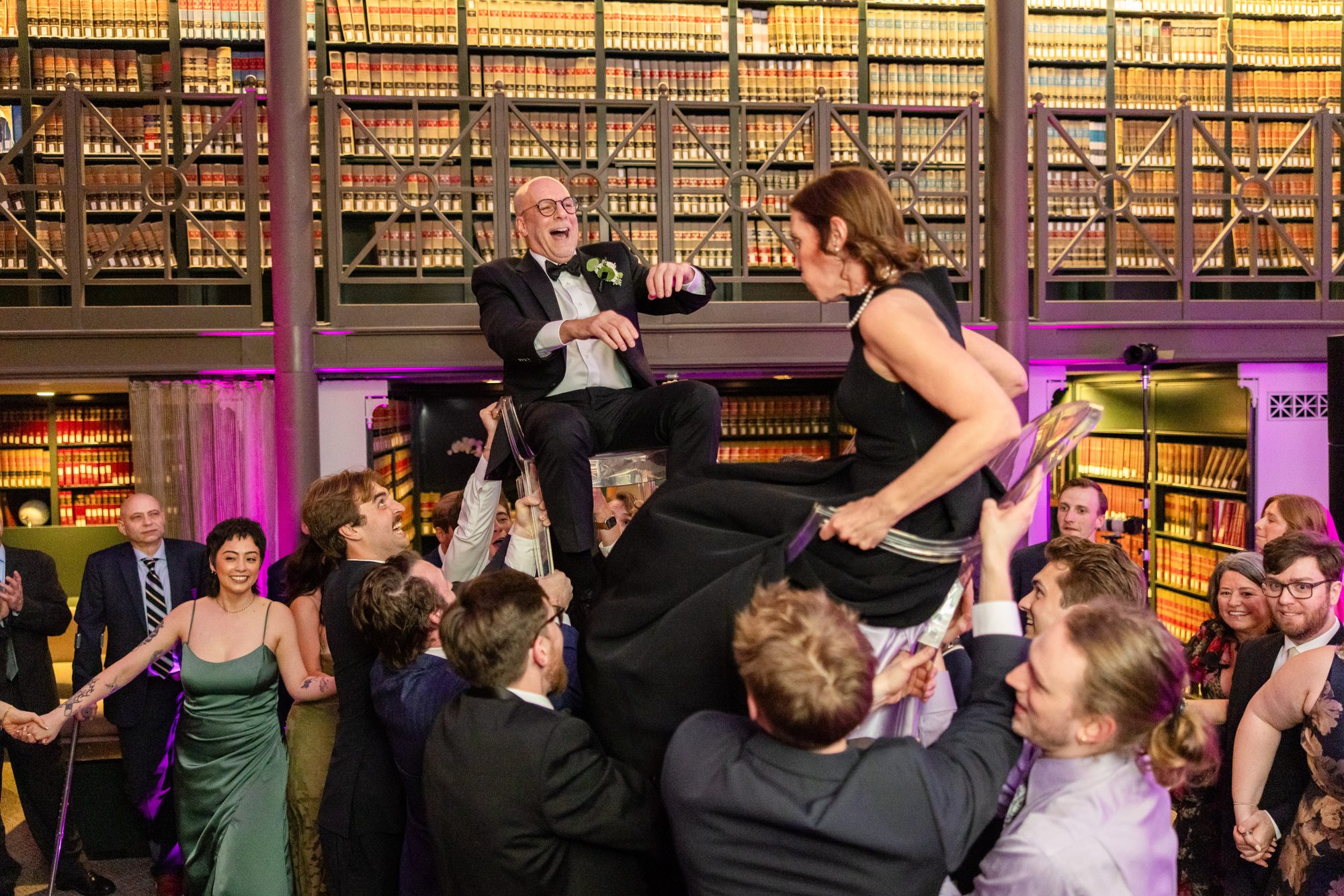 Guests lifted in chairs during a celebratory dance in The Library